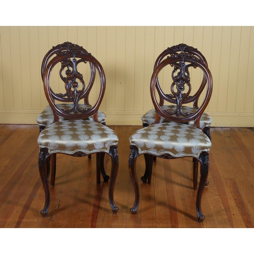 50 - A SET OF FOUR 19TH CENTURY CARVED MAHOGANY DINING CHAIRS with pierced vertical splats and upholstere... 