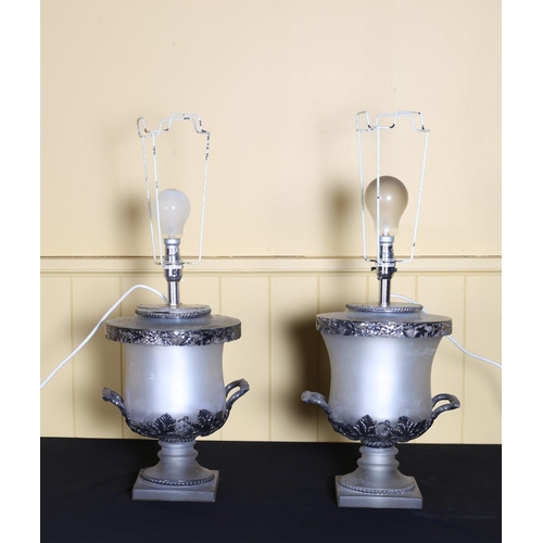 506 - A PAIR OF SILVER PLATED AND FROSTED GLASS TABLE LAMPS each of urn form with twin intertwined handles... 