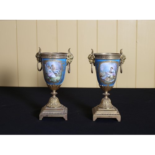 515 - A PAIR OF FRENCH SEVRES AND GILT BRASS URNS each of ovoid tapering form with ram head mask ring hand... 