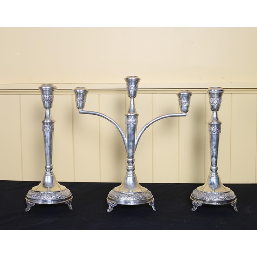 524 - A GARNITURE OF THREE AMERICAN SILVER EMBOSSED CANDLESTICKS comprising a three branch candelabrum 35c... 