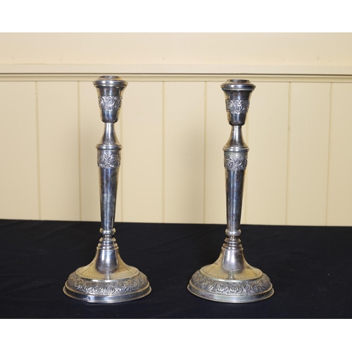 525 - A PAIR OF AMERICAN SILVER CANDLESTICKS embossed with stylised flowerheads and foliage 32cm (h)