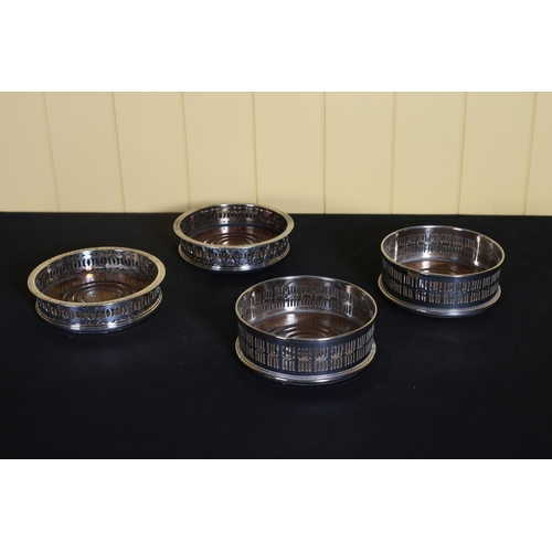 538 - TWO PAIRS OF SILVER PLATED WINE COASTERS each with a pierced rim with hardwood inset (4)