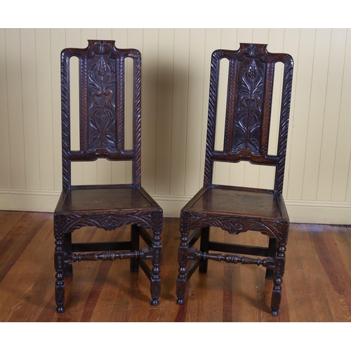 558 - A PAIR OF 19TH CENTURY CARVED OAK HALL CHAIRS each with a foliate carved splat above a panelled seat... 