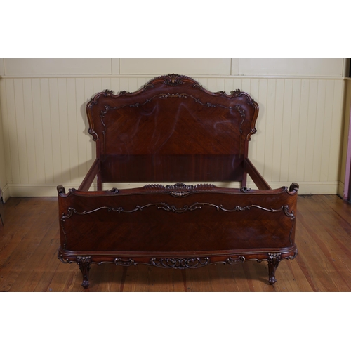 625 - A CONTINENTAL KINGWOOD AND PARCEL GILT BED the serpentine headboard with foliate scroll carved crest... 