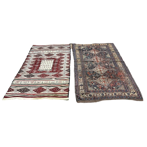 715 - TWO ORIENTAL WOOL RUGS (AF) The larger 210cm (l) x 127cm (w), the smaller 207cm (l) x 110cm (w)