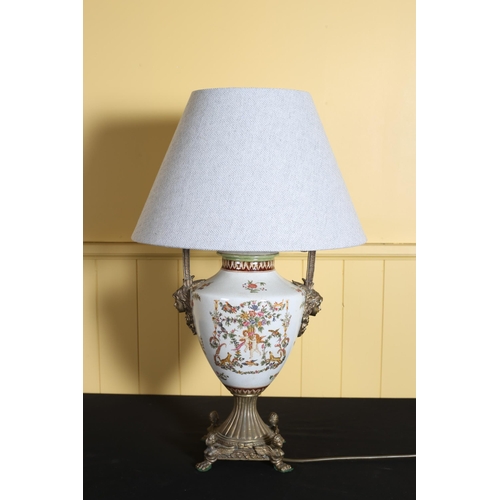 74 - A CONTINENTAL PORCELAIN AND GILT BRASS TABLE LAMP of urn form the white ground decorated with flower... 