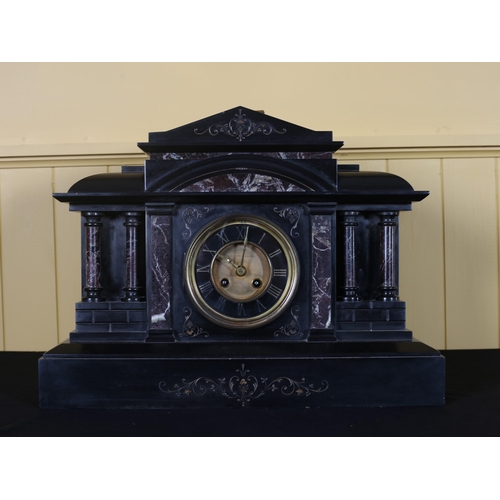 222 - A VINTAGE BLACK AND VEINED MARBLE MANTEL CLOCK of architectural outline the gilt brass dial with Rom... 