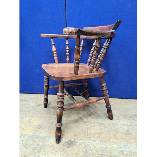 421 - A VINTAGE OAK SMOKER'S BOW CHAIR with baluster splats and panel seat on conforming legs 78cm (h) 69c... 