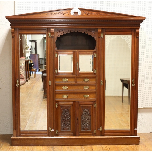 11 - AN EDWARDIAN CARVED MAHOGANY COMBINATION WARDROBE bears plaque 'Pimm Brothers Dublin' the architectu... 