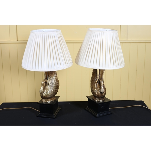 139 - A PAIR OF CONTINENTAL GILT AND EBONISED TABLE LAMPS each in the form of a swan with pleated shades 6... 