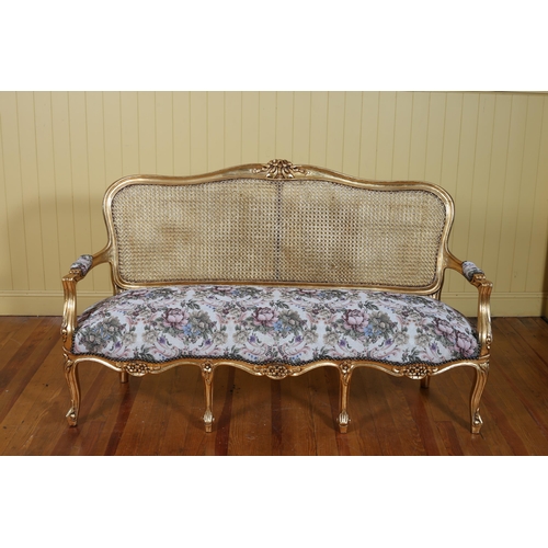 193 - A CONTINENTAL GILTWOOD BERGERE AND UPHOLSTERED SETTEE the serpentine top rail with flowerhead and fo... 