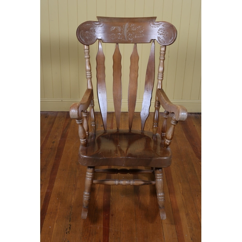 31 - A STAINED HARDWOOD ROCKING CHAIR the curved top rail with vertical splats and a shaped seat with scr... 