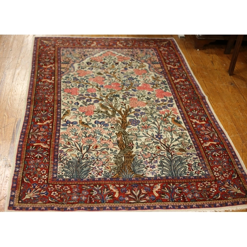 34 - AN ORIENTAL WOOL RUG the beige light pink and wine ground with central panel filled with birds and a... 