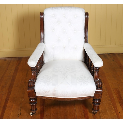 355 - A 19TH CENTURY CARVED MAHOGANY AND UPHOLSTERED ARMCHAIR with deep buttoned upholstered back and seat... 