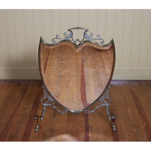 367 - A 19TH CENTURY BRASS MIRRORED FIRESCREEN the shield shaped bevelled glass plate with carrying handle... 