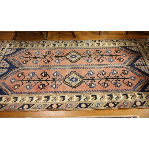 37 - AN ORIENTAL WOOL RUG the light pink, light blue and indigo ground with central panel filled with ser... 