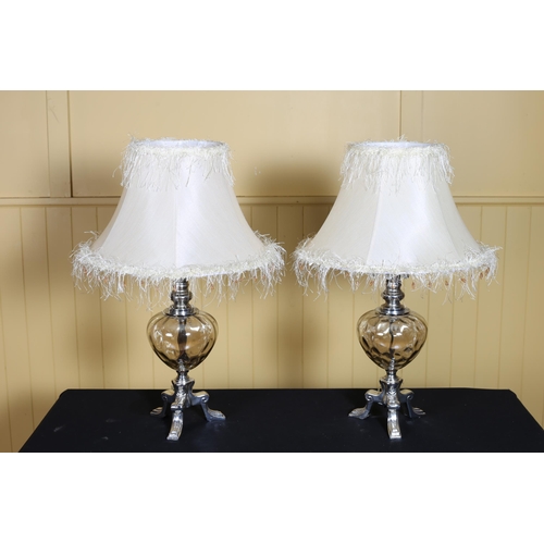 374 - A PAIR OF DESIGNER PLATED AND GLAZED TABLE LAMPS each of bulbous form on tripod support with shades ... 