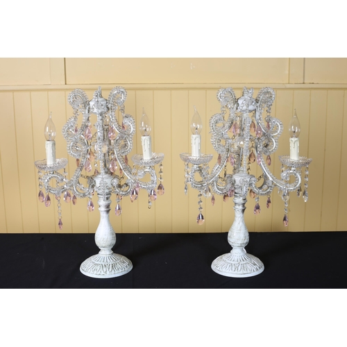 391 - A PAIR OF CONTINENTAL WHITE PAINTED METAL AND MOULDED GLASS THREE BRANCH TABLE CANDELABRA with scrol... 