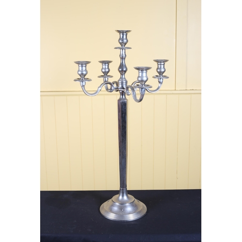 392 - A PLATED FIVE BRANCH CANDELABRUM with scroll arms and faceted column above a circular spreading foot... 