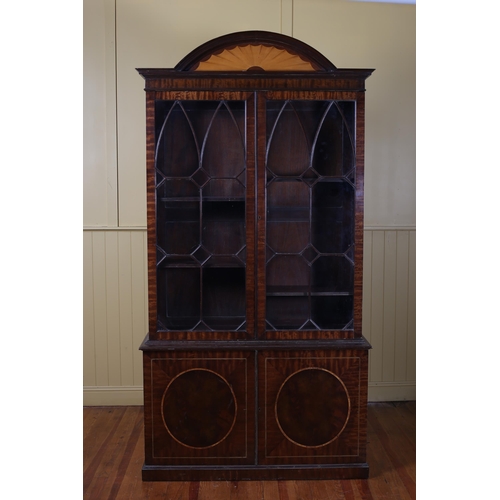 393 - AN EDWARDIAN MAHOGANY AND SATINWOOD INLAID BOOKCASE the arched pediment above a pair of astragal gla... 