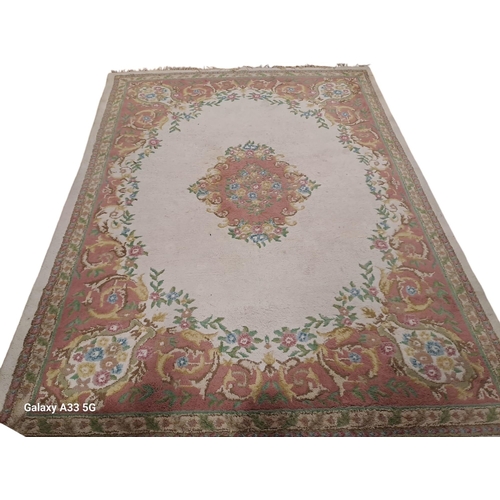 514 - A WOOL RUG the light pink and beige ground with central floral panel within a conforming panel 390cm... 