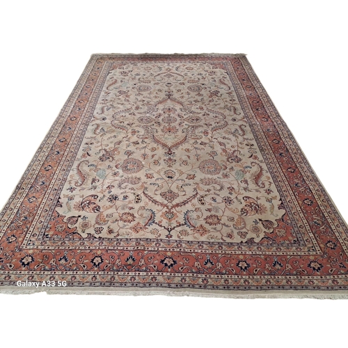 519 - A TABRIZ WOOL RUG the beige ground with central floral panel within a conforming border 324cm (l) x ... 