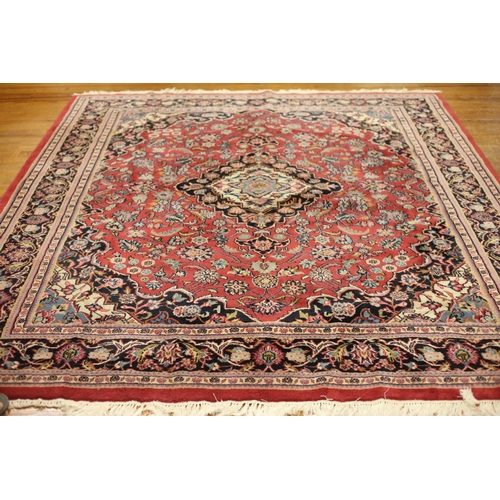 61 - A KESHAN WOOL RUG the multicolour ground with central panel filled with flowerheads and foliage with... 