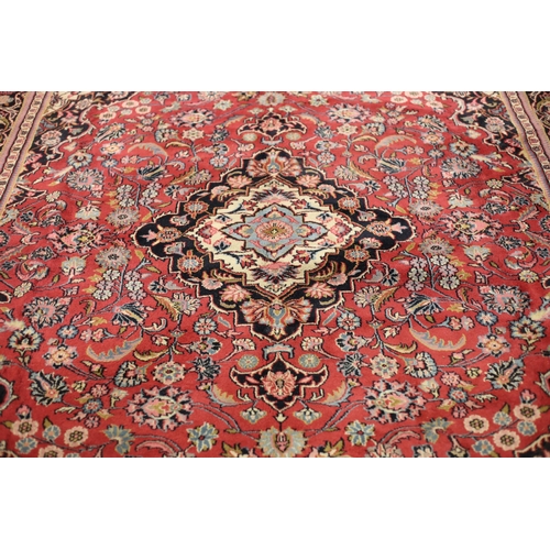 61 - A KESHAN WOOL RUG the multicolour ground with central panel filled with flowerheads and foliage with... 