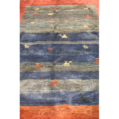 64 - A MOROCCAN GABBEH WOOL RUG the blue and wine ground filled with stylised animals 276cm (l) x 200cm (... 