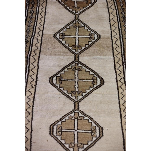 65 - A CAUCUS WOOL RUNNER the beige ground with central diamond shaped panels within a conforming border ... 