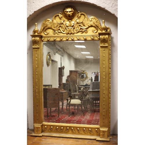 67 - A CONTINENTAL GILT FRAME MIRROR of rectangular arched outline the shaped plate between fluted and fo... 