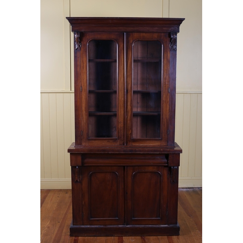 73 - A 19TH CENTURY MAHOGANY TWO DOOR LIBRARY BOOKCASE containing three adjustable shelves above a frieze... 