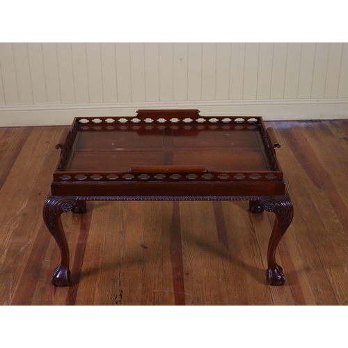 83 - A CHIPPENDALE STYLE CHERRYWOOD SERVING TRAY ON STAND the pierced gallery with scroll handles raised ... 