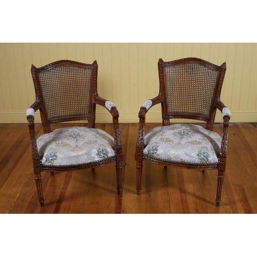 92 - A PAIR OF CONTINENTAL CARVED BEECHWOOD BERGERE AND UPHOLSTERED ARMCHAIRS each with a shaped back and... 