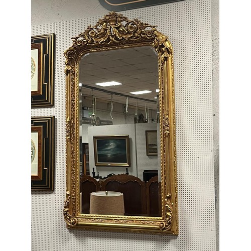 174 - A CONTINENTAL GILT FRAME MIRROR the rectangular bevelled glass plate within a foliate and flowerhead... 