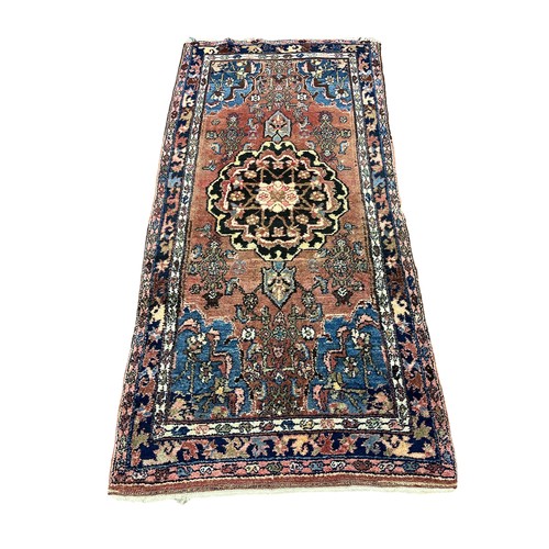 520 - A TURKISH TRIBAL RUG the light pink and light blue ground with central panel filled with stylised fl... 