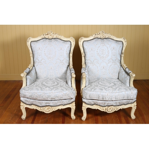 69 - A PAIR OF CONTINENTAL CREAM PAINTED AND UPHOLSTERED ARMCHAIRS each with a flowerhead and foliate car... 