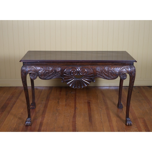 255 - A 19TH CENTURY IRISH SIDE TABLE of rectangular outline with shell scroll and flowerhead carved apron... 