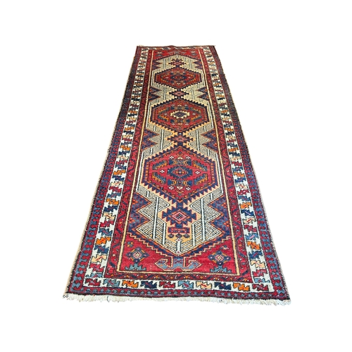 156 - A TURKISH WOOL RUNNER the multicolour ground with central diamond shaped panels filled with palmette... 