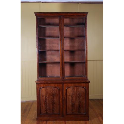 172 - A 19TH CENTURY MAHOGANY TWO DOOR LIBRARY BOOKCASE the moulded cornice above a pair of glazed doors c... 