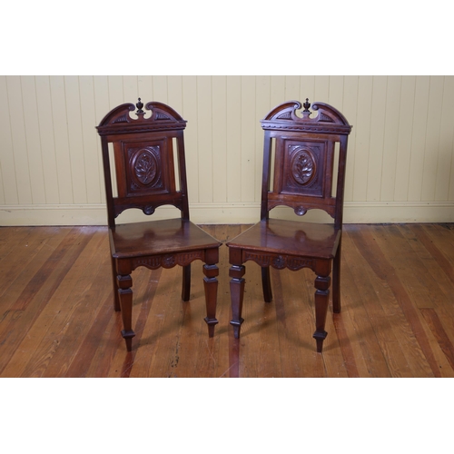 177 - A PAIR OF EDWARDIAN CARVED MAHOGANY HALL CHAIRS each with a scroll top rail above a carved splat and... 