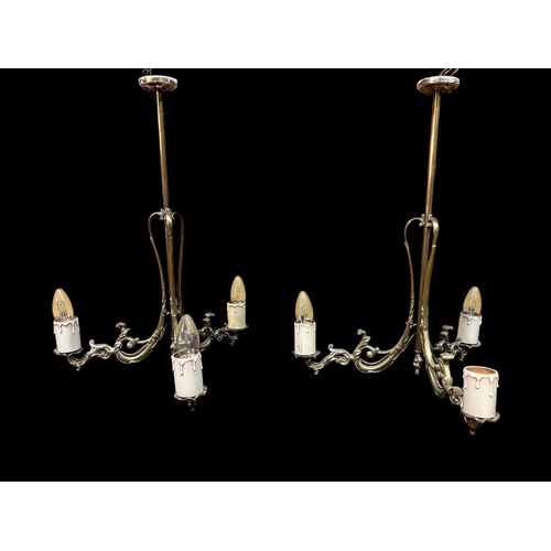 227 - A PAIR OF VINTAGE BRASS THREE BRANCH CENTRE LIGHTS with pierced C-scroll and foliate cast arms 54cm ... 