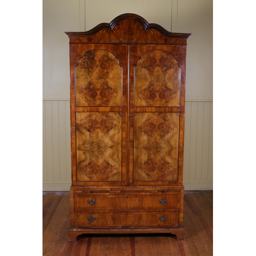 25 - A GEORGIAN STYLE WALNUT WARDROBE ON CHEST the arched cornice above a pair of panel doors containing ... 