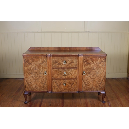 32 - A VINTAGE WALNUT SIDEBOARD of rectangular breakfront outline the shaped top above three frieze drawe... 