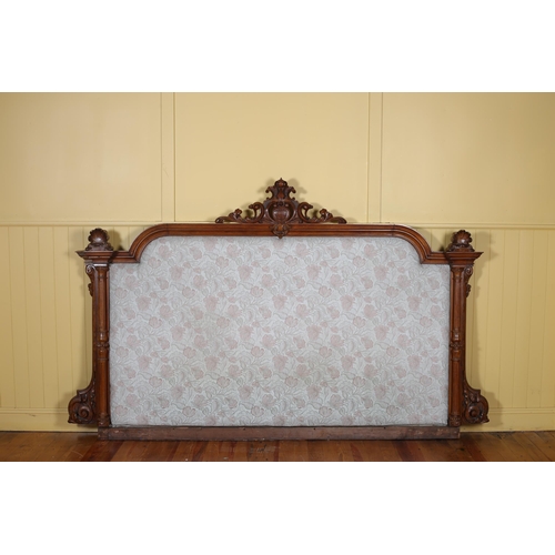 42 - A 19TH CENTURY MAHOGANY AND UPHOLSTERED HEADBOARD of rectangular arched outline the upholstered pane... 