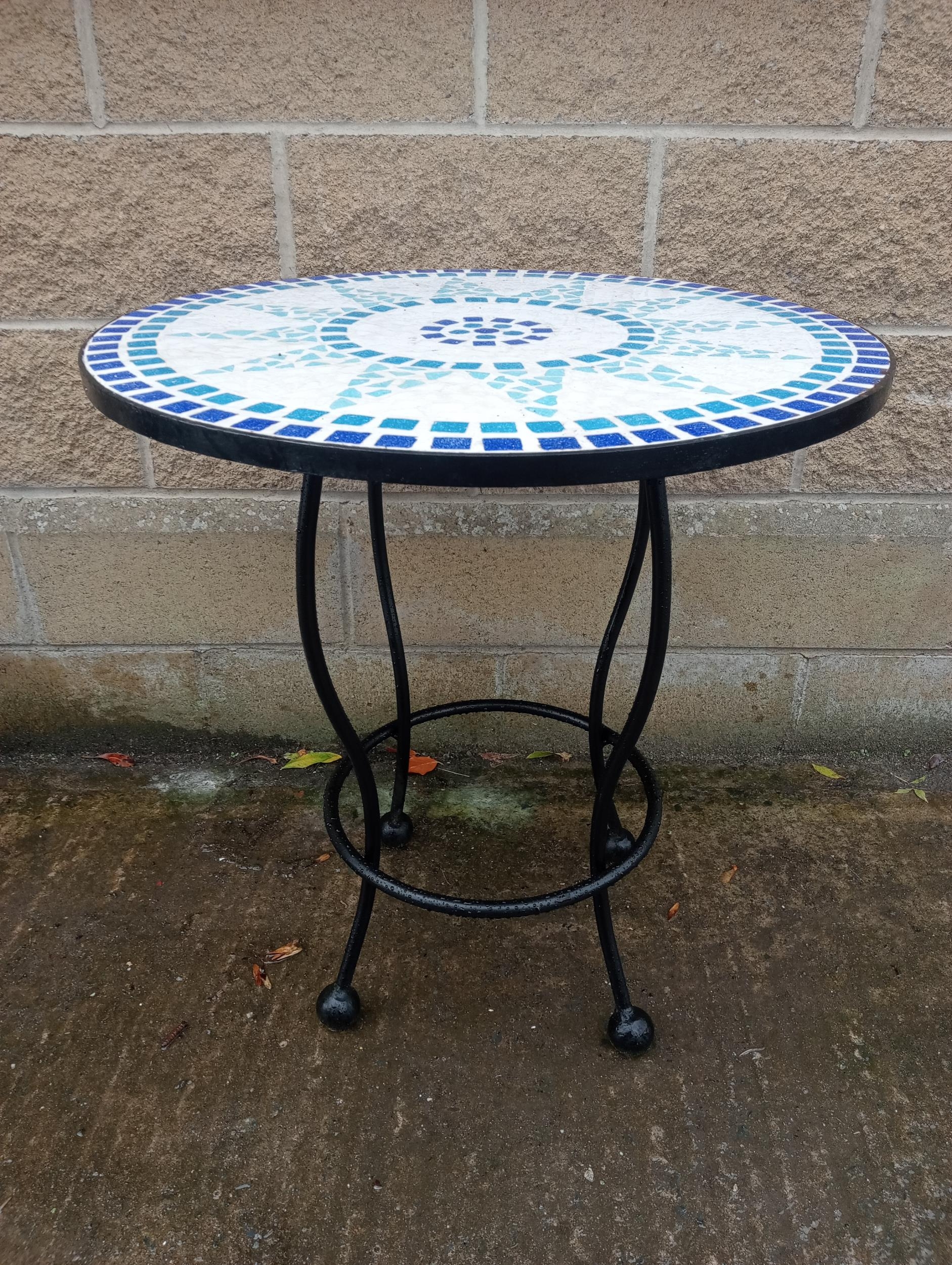 A WROUGHT IRON AND MOSAIC PATIO TABLE of circular outline on splayed