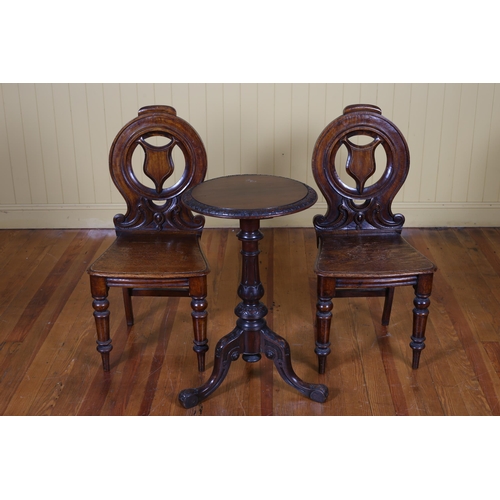 51 - A PAIR OF 19TH CENTURY OAK HALL CHAIRS each with an armorial splat above a panel seat on baluster le... 