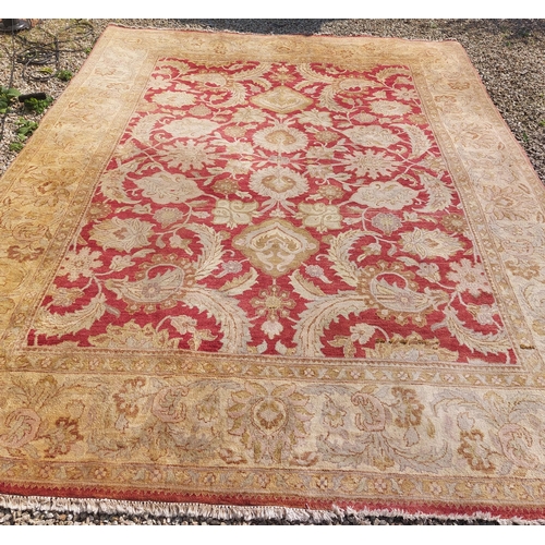 634 - AN INDIAN WOOL RUG the gold and wine ground pattern rug the central panel filled with flowerheads an... 