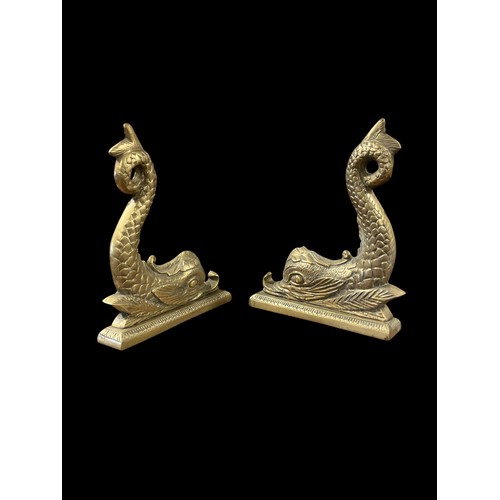 596 - A PAIR OF BRASS DOOR STOPS each in the form of a dolphin raised on a rectangular platform base 35cm ... 