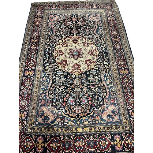 641 - AN ORIENTAL WOOL RUG the multicolour ground with central panel filled with stylised flowerheads and ... 